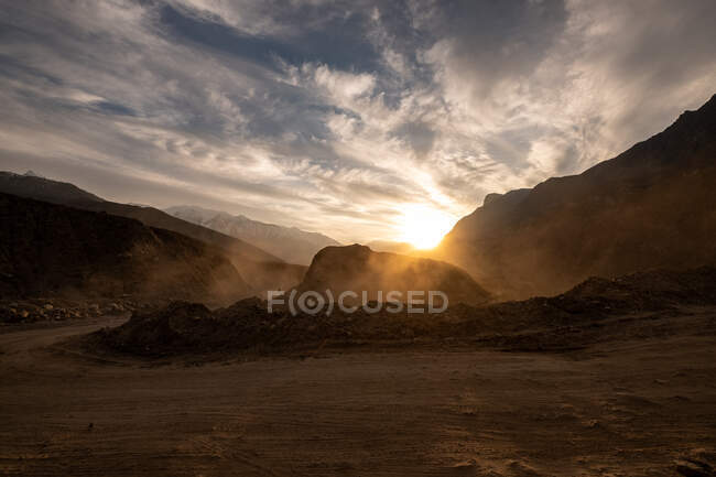 Scena polverosa con rocce canyon e cielo nuvoloso al tramonto — Foto stock