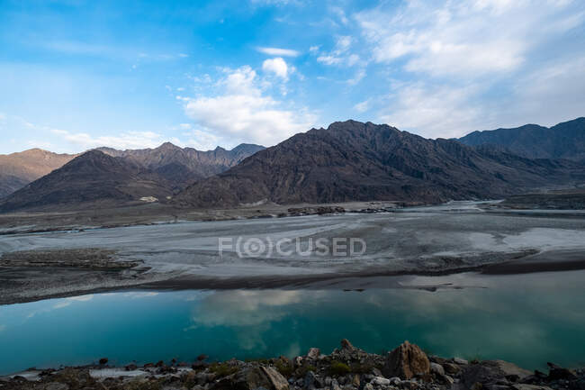 Beau paysage montagneux avec lac sous ciel nuageux bleu — Photo de stock