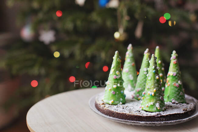 Arbre de Noël avec des décorations et des branches de sapin sur un fond en bois — Photo de stock