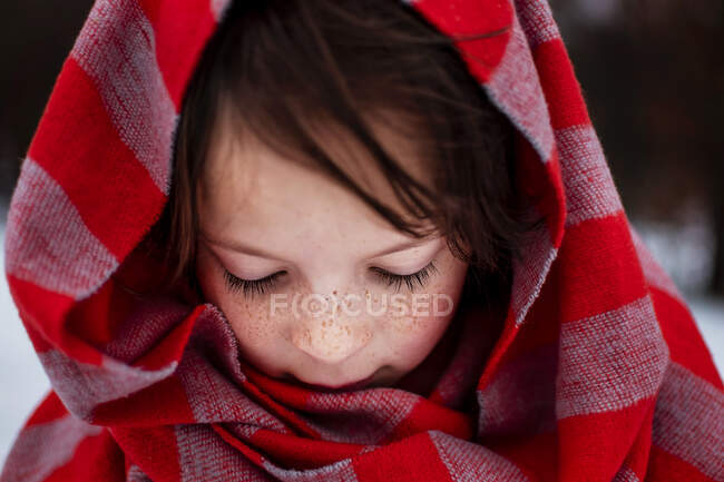 Portrait of a girl standing in snow wearing a scarf around her head, United States — Stock Photo