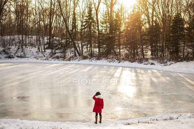 Menina de pé na frente de um lago congelado no inverno, Estados Unidos — Fotografia de Stock