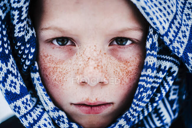 Gros plan portrait d'un garçon avec des taches de rousseur enveloppé dans une écharpe, États-Unis — Photo de stock