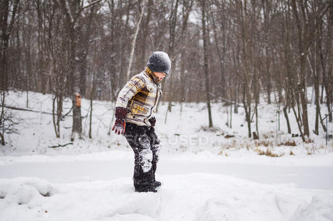 Хлопчик стоїть в сніжному зимовому парку сцена — стокове фото