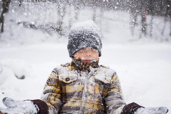 Niño lanzando nieve en invierno parque escena - foto de stock