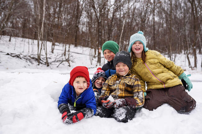 Cinco niños felices en la nieve en la escena del bosque de invierno - foto de stock