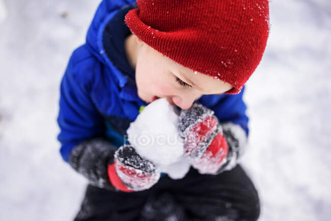 Vista aérea de un niño comiendo nieve, Wisconsin, Estados Unidos - foto de stock