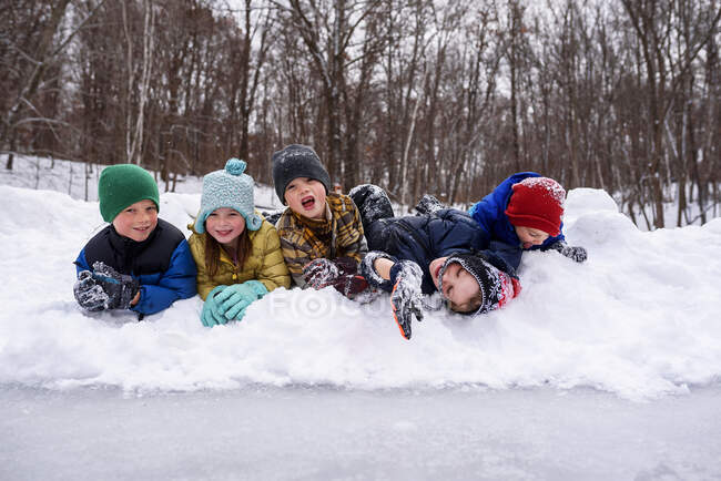 Cinco crianças felizes na neve na cena da floresta de inverno — Fotografia de Stock