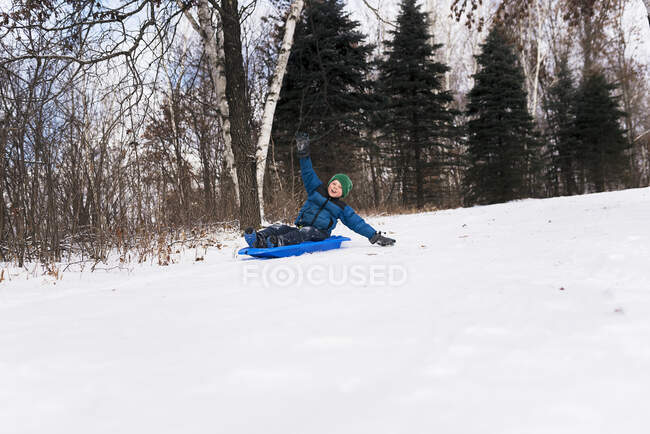 Junge auf einem Schlitten lacht, Wisconsin, Vereinigte Staaten — Stockfoto
