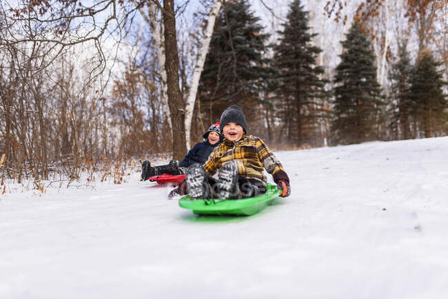 Due ragazzi su una slitta ridendo, Wisconsin, Stati Uniti — Foto stock