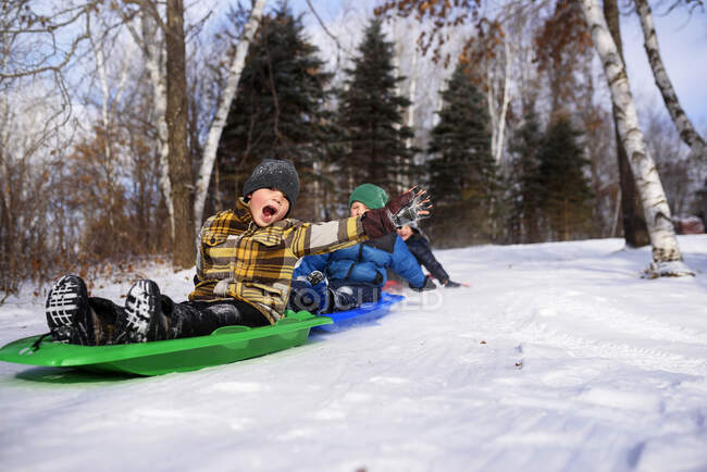 Tre ragazzi su una slitta ridendo, Wisconsin, Stati Uniti — Foto stock