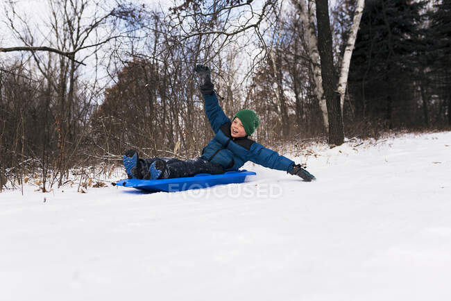 Boy on a sledge laughing, Wisconsin, Estados Unidos — Fotografia de Stock