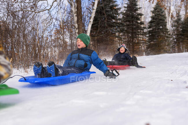 Dos chicos en un trineo riendo, Wisconsin, Estados Unidos - foto de stock