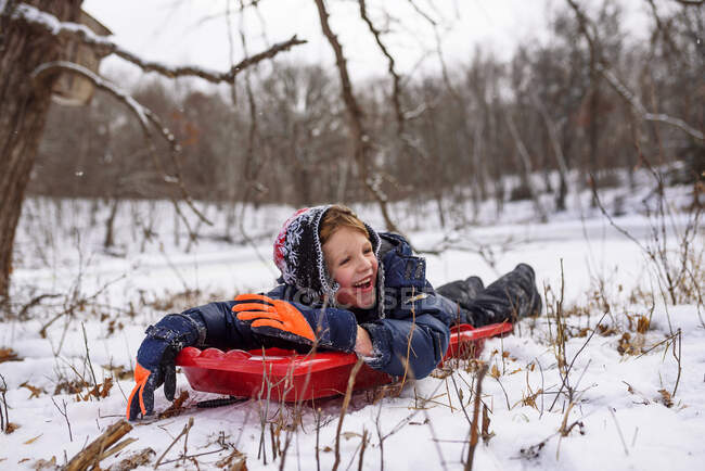 Boy lying on a sledge, Wisconsin, Estados Unidos — Fotografia de Stock