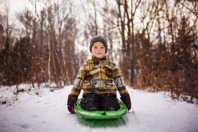 Boy sitting on a sledge, Wisconsin, Estados Unidos — Fotografia de Stock