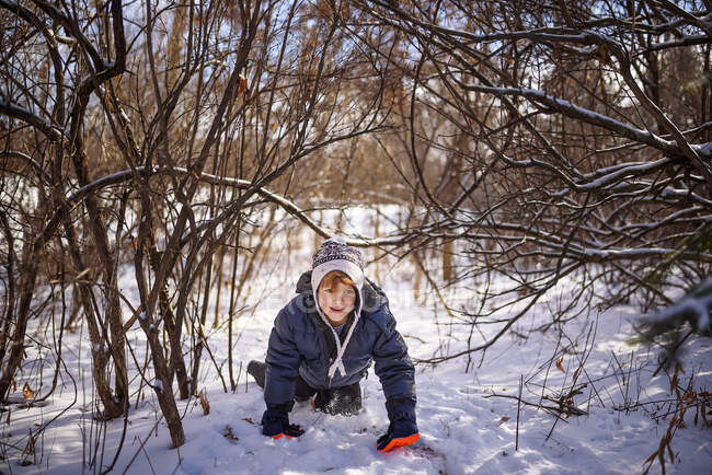 Boy crawling through the snow, Wisconsin, Estados Unidos — Fotografia de Stock