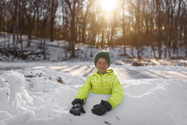 Мальчик-кузнец, стоящий в снежной крепости, США — стоковое фото
