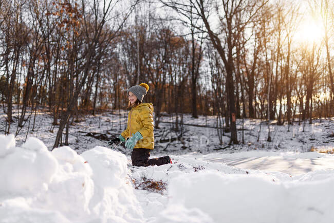 Lächelndes Mädchen beim Bau einer Schneefestung, Vereinigte Staaten — Stockfoto