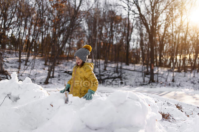Chica construyendo un fuerte de nieve, Estados Unidos - foto de stock