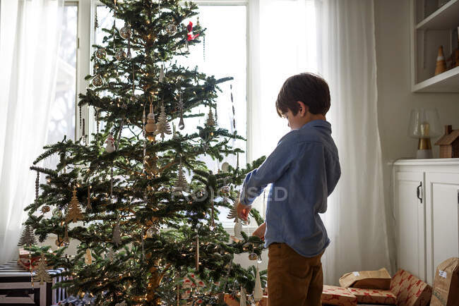 Rapaz a decorar uma árvore de Natal — Fotografia de Stock