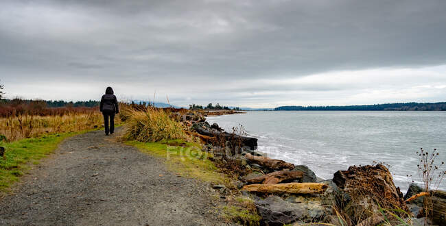 Mujer caminando a lo largo de un sendero costero, Canadá - foto de stock