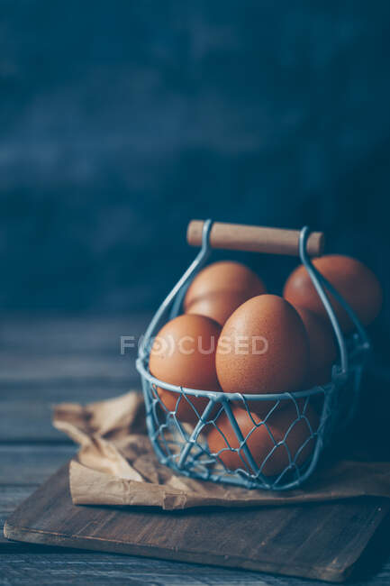 Ovos em uma cesta metálica em uma mesa — Fotografia de Stock