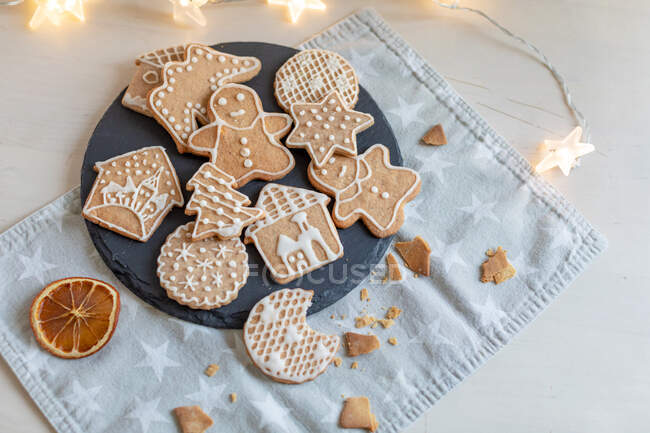 Biscuits au pain d'épice de Noël sur une table avec des lumières de fées — Photo de stock