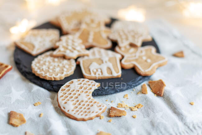 Christmas gingerbread cookies on a table with fairy lights — Stock Photo