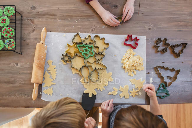 Vista aerea di tre bambini che fanno biscotti di Natale — Foto stock