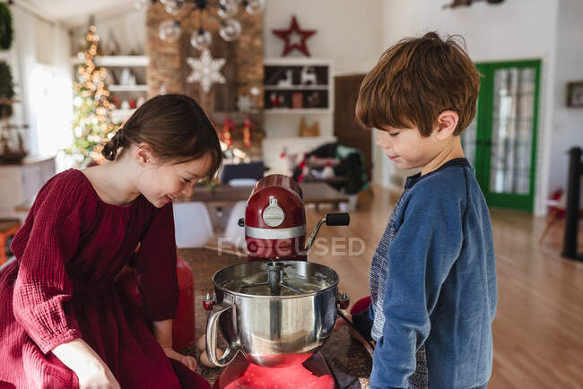 Dos niños en la cocina haciendo un pastel - foto de stock