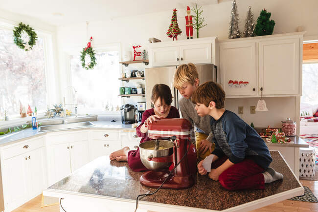 Três crianças na cozinha fazendo um bolo — Fotografia de Stock