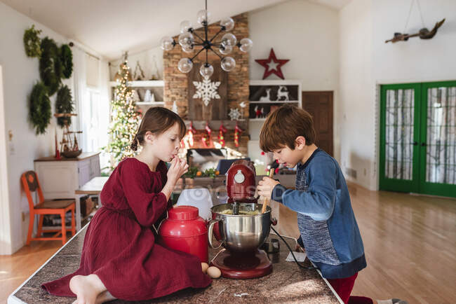 Двое детей на кухне делают торт — стоковое фото