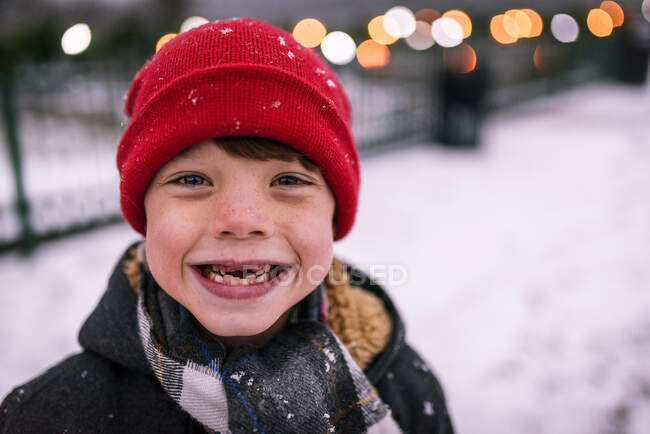 Ritratto di un ragazzo sorridente con i denti mancanti in piedi nella neve, Stati Uniti — Foto stock
