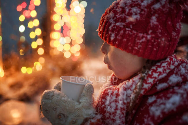 Chica parada al aire libre bebiendo chocolate caliente, Estados Unidos - foto de stock