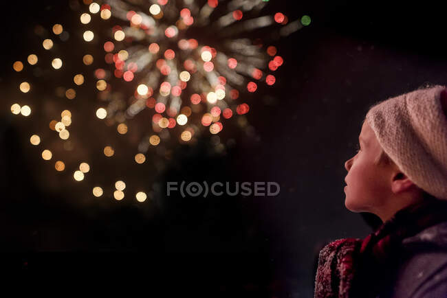 Visão traseira de um menino assistindo a uma exibição de fogos de artifício — Fotografia de Stock