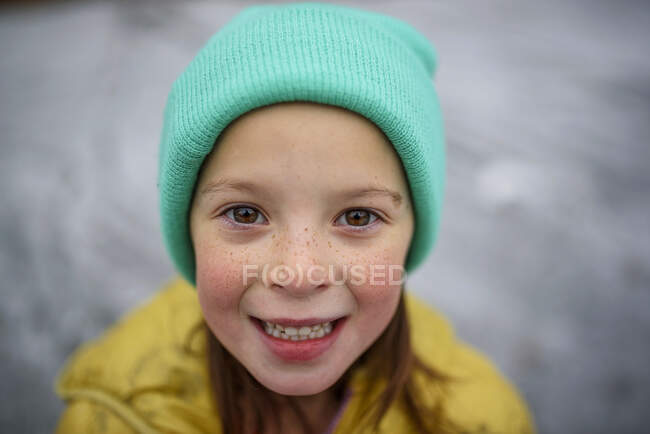 Retrato de una chica sonriente con un sombrero lanudo - foto de stock
