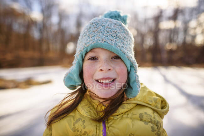 Портрет усміхненої дівчини, що стоїть біля замерзлого ставка (США). — стокове фото