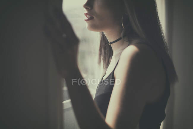 Девочка-подросток смотрит в окно — стоковое фото