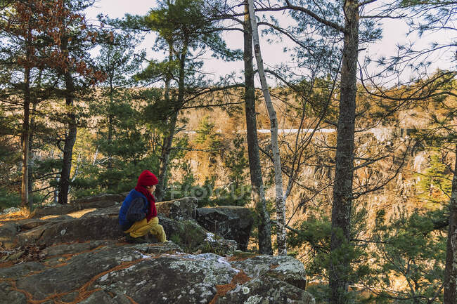 Menino sentado ao ar livre na floresta, Estados Unidos — Fotografia de Stock