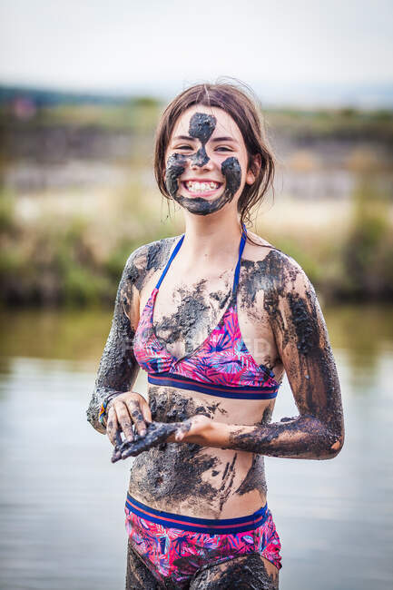 Smiling Girl standing in Atanasovsko Lake covering herself in mud, Burgas, Bulgaria — Stock Photo