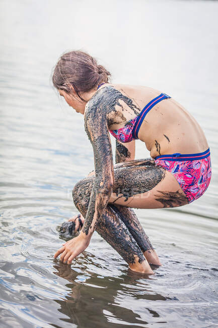 Girl standing in Atanasovsko Lake covering herself in mud, Burgas, Bulgaria — Stock Photo