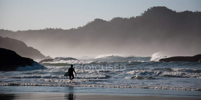Чоловік ходить на пляжі вранці — стокове фото