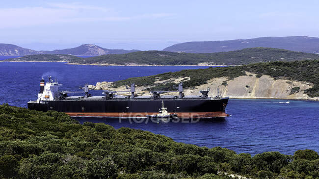 Elevated view of sunny harbor with green hills and ship on water — Stock Photo