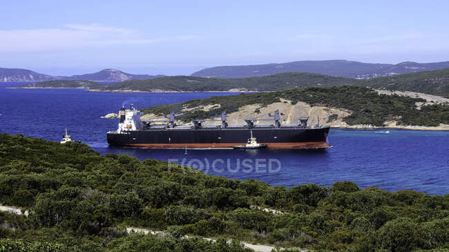 Erhöhter Blick auf den sonnigen Hafen mit grünen Hügeln und Schiff auf dem Wasser — Stockfoto