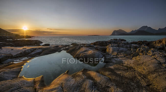Picturesque view of rocky coast and wavy sea at sunset — Stock Photo