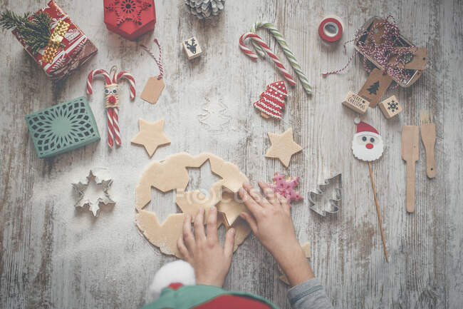 Child making Christmas cookies on table, top view — Stock Photo