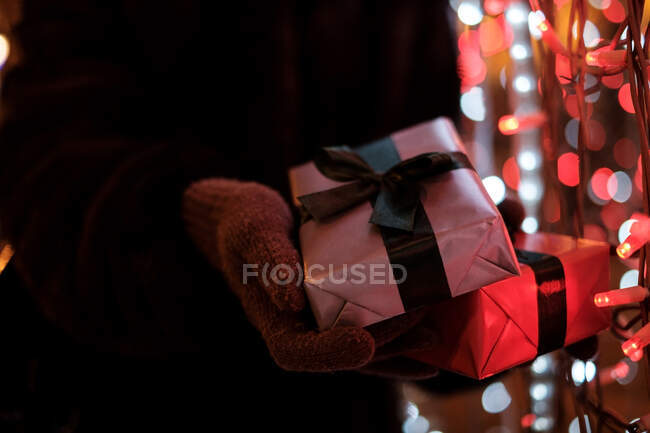 Manos femeninas en guantes sosteniendo cajas de regalo, vista cercana - foto de stock