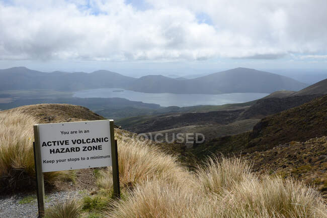 Panneau d'avertissement à beau paysage montagneux avec lac — Photo de stock