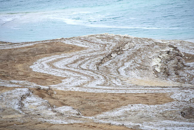 Піщана прибережна поверхня каменю з видом на океанські хвилі — стокове фото