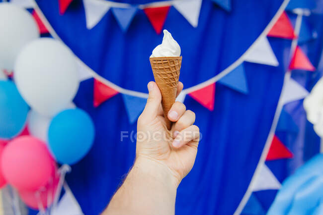 Mano humana sosteniendo un cono de helado - foto de stock
