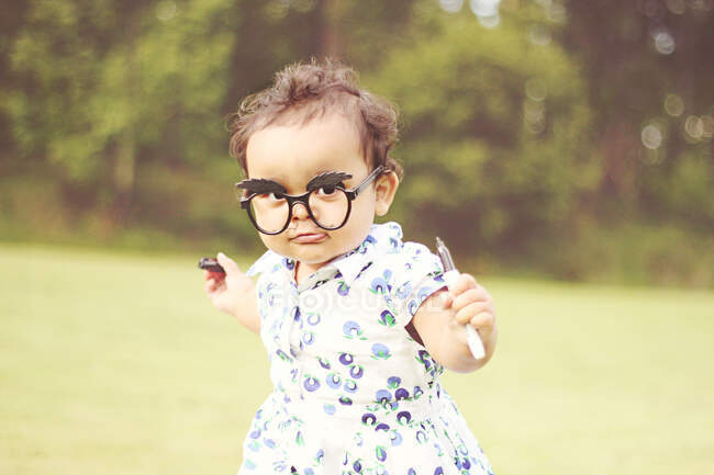 Portrait d'une fille portant des lunettes de nouveauté avec une moustache dessinée sur son visage — Photo de stock